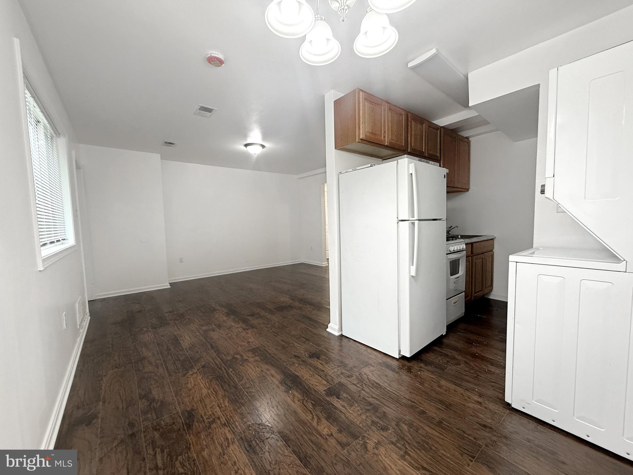 506 Eastern Avenue Northeast, Unit 102 Washington, DC 20019 - Photo 7 of 13 a kitchen with kitchen island wooden floors and refrigerator