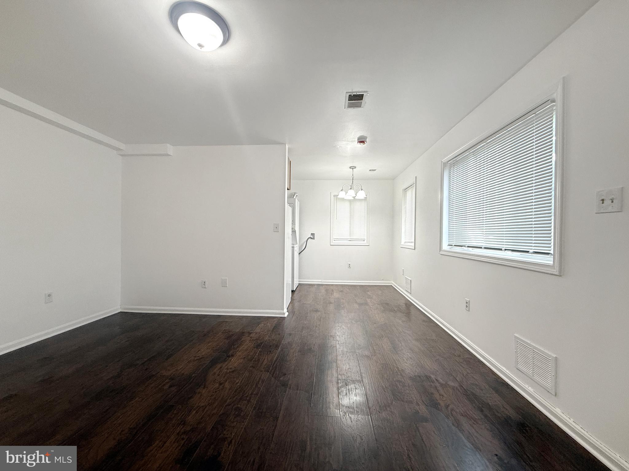 506 Eastern Avenue Northeast, Unit 102 Washington, DC 20019 - Photo 8 of 13 an empty room with wooden floor and windows