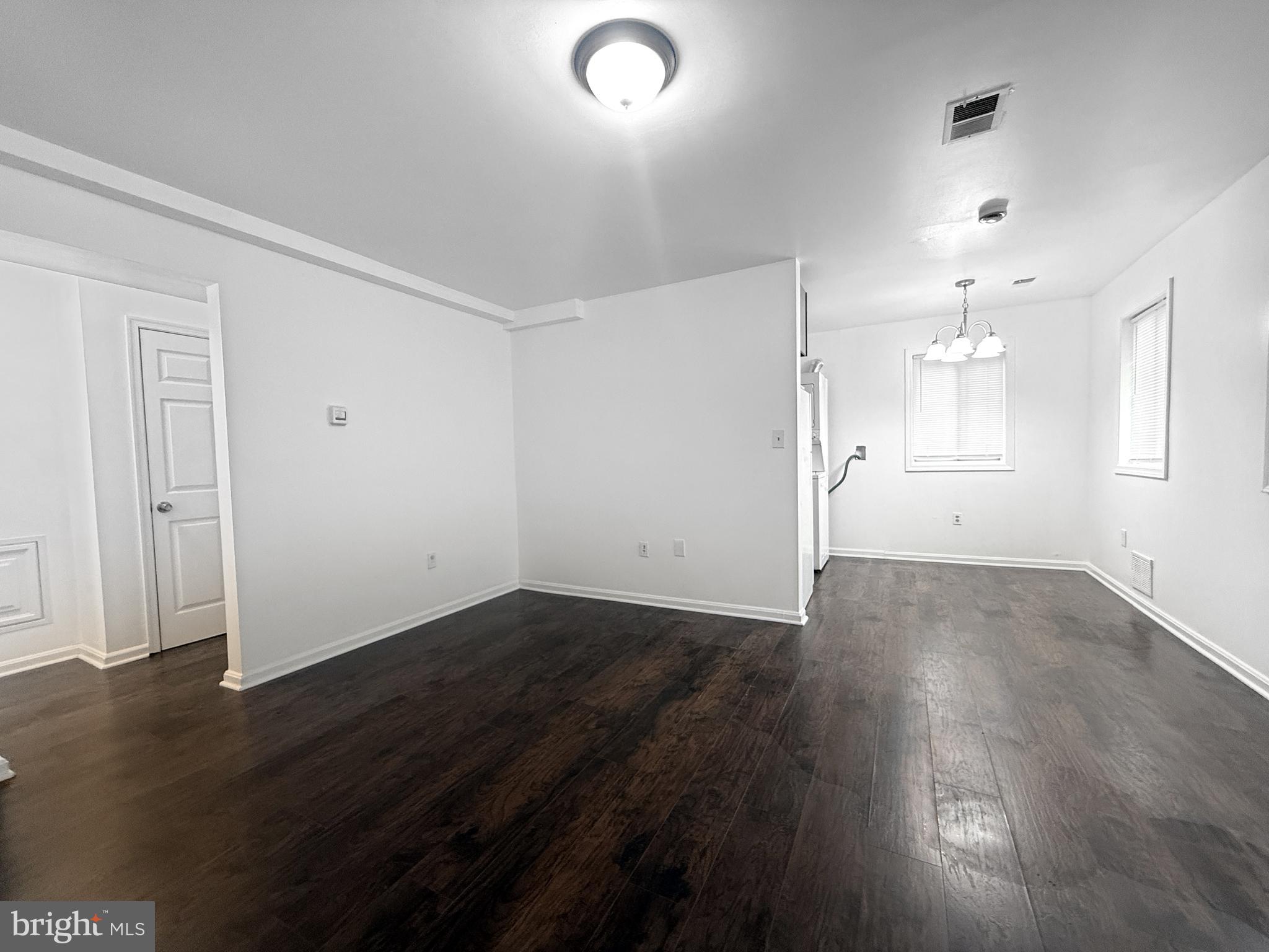 506 Eastern Avenue Northeast, Unit 102 Washington, DC 20019 - Photo 9 of 13 an empty room with wooden floor and windows