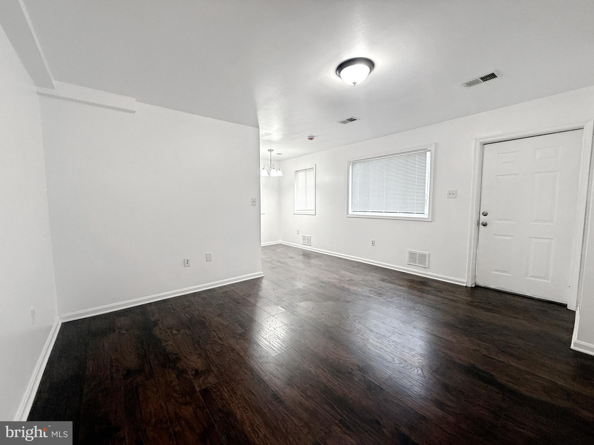 506 Eastern Avenue Northeast, Unit 102 Washington, DC 20019 - Photo 10 of 13 an empty room with wooden floor and windows