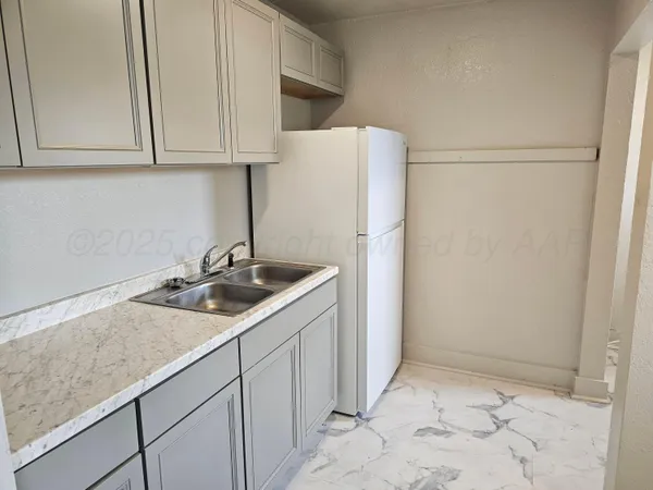 a kitchen with a sink and a refrigerator