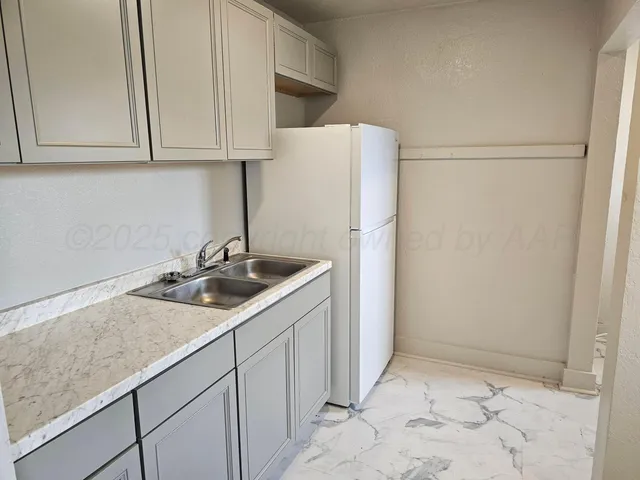 a kitchen with a sink and a refrigerator