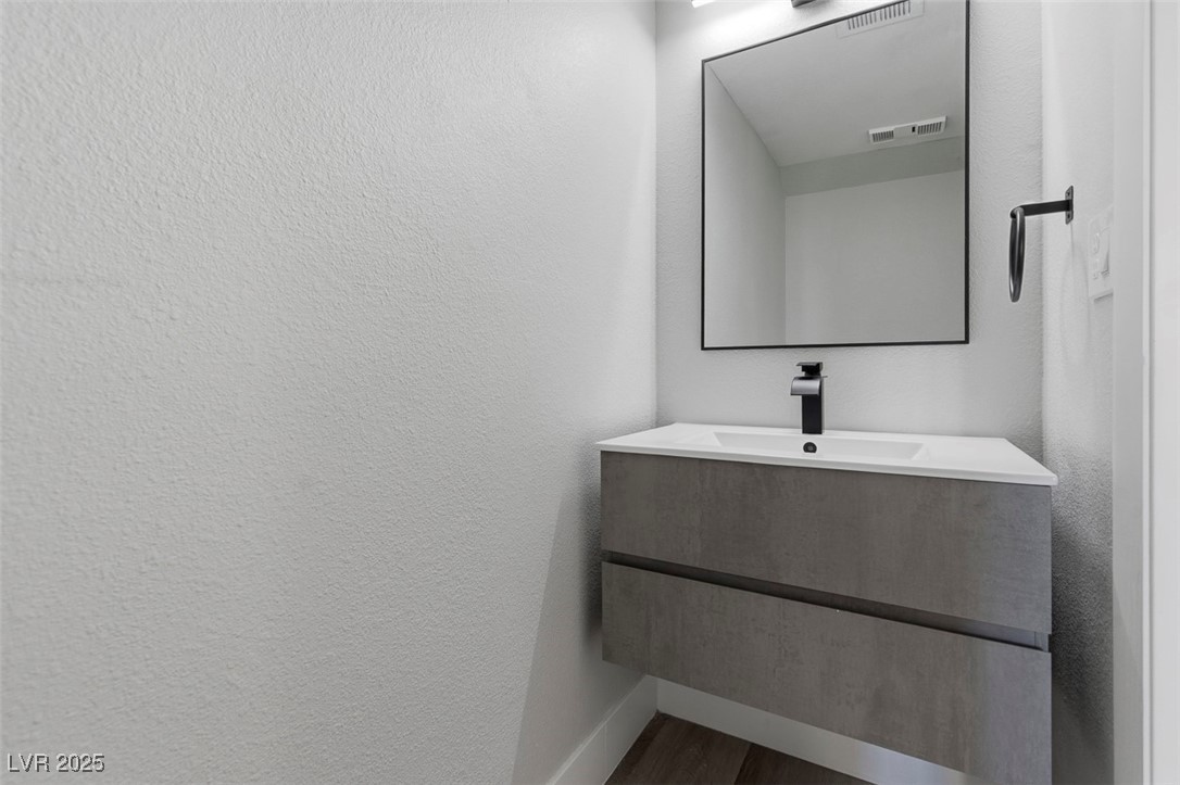 3517 Rio Robles Drive, Unit D North Las Vegas, NV 89030 - Photo 19 of 35 Bathroom featuring vanity, a textured wall, and dark wood finished floors
