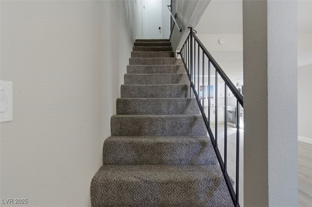 3517 Rio Robles Drive, Unit D North Las Vegas, NV 89030 - Photo 20 of 35 Stairway featuring a textured wall and wood finished floors