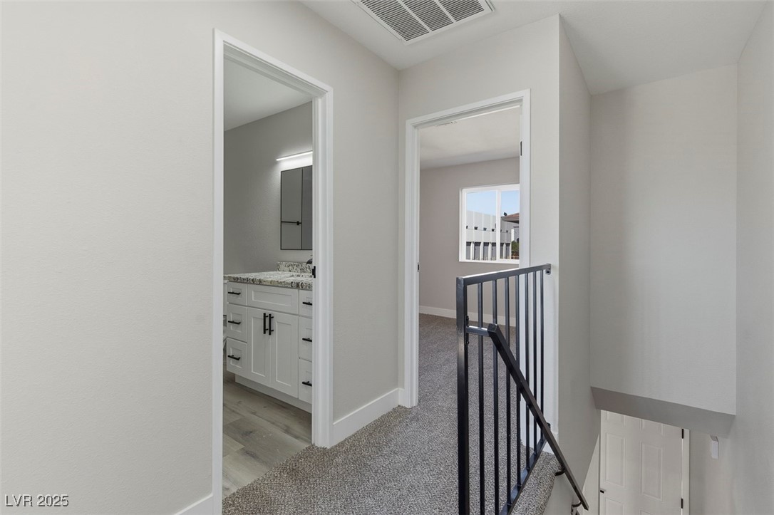 3517 Rio Robles Drive, Unit D North Las Vegas, NV 89030 - Photo 21 of 35 Hallway featuring an upstairs landing and light colored carpet