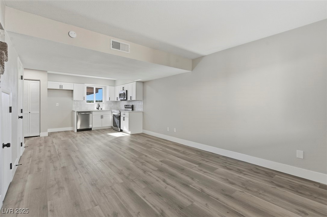 3517 Rio Robles Drive, Unit D North Las Vegas, NV 89030 - Photo 9 of 35 Unfurnished living room featuring light wood-style floors and baseboards
