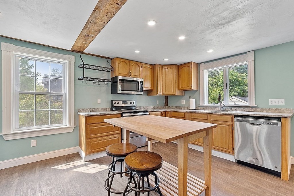230 7 Bridge Road Lancaster, MA 01523 - Photo 14 of 33 a kitchen with stainless steel appliances granite countertop a stove a sink dishwasher a microwave oven and a refrigerator with wooden floor