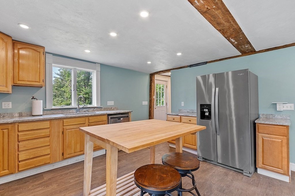 230 7 Bridge Road Lancaster, MA 01523 - Photo 16 of 33 a kitchen with sink a refrigerator and chairs