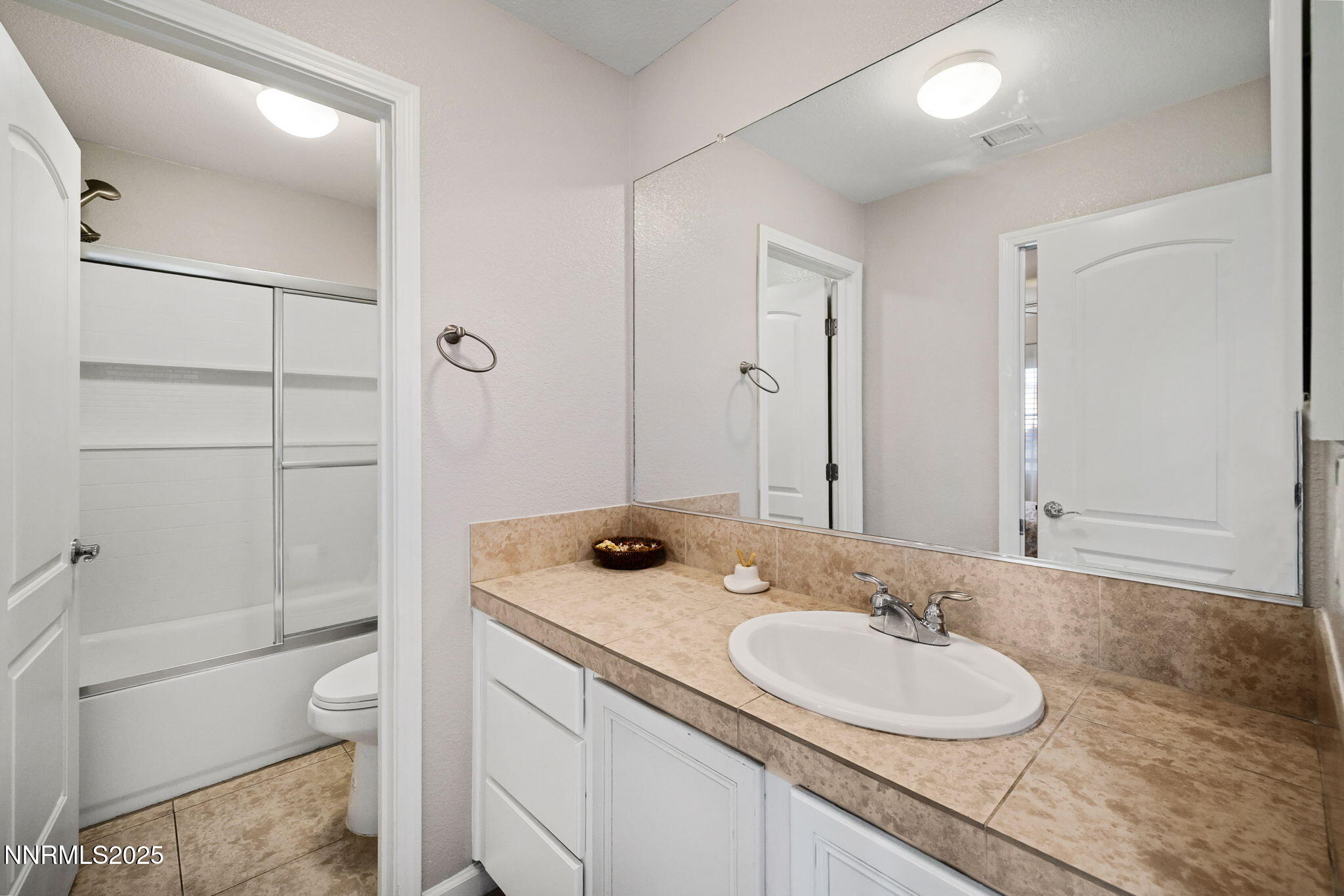 1876 Braemore Drive Reno, NV 89521 - Photo 26 of 34 a bathroom with a granite countertop sink toilet a mirror and shower