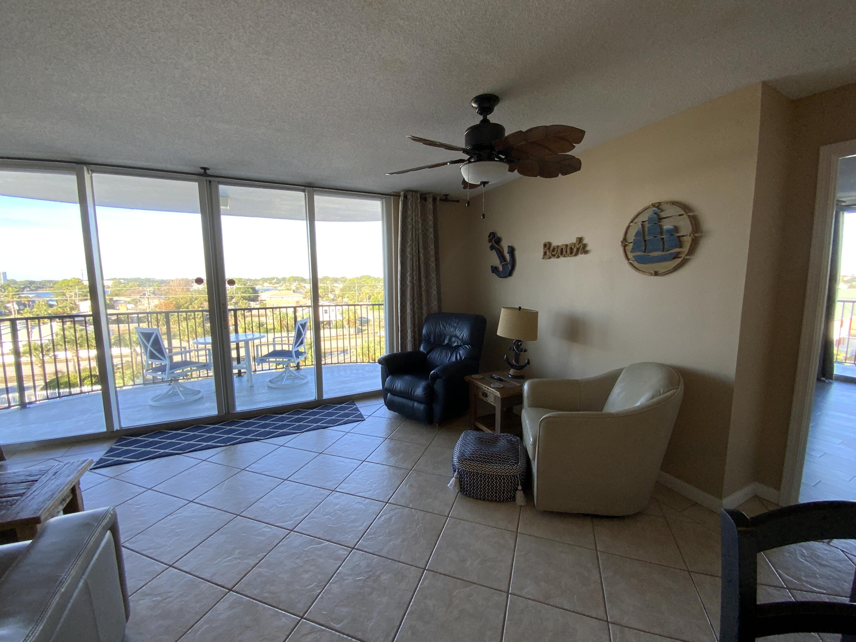 670 Santa Rosa Boulevard, Unit 503 Fort Walton Beach, FL 32548 - Photo 13 of 44 a living room with couches floor to ceiling window and a flat screen tv
