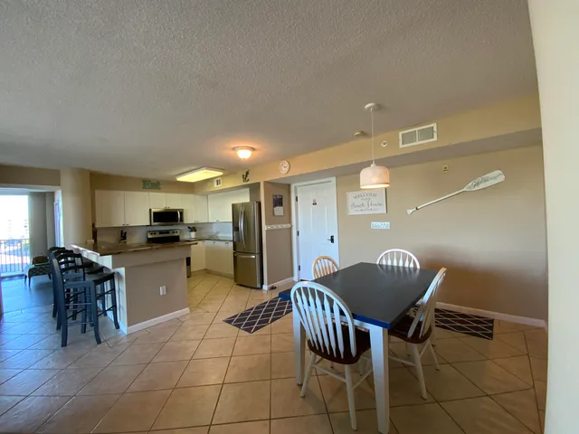 a kitchen with a dining table chairs and a refrigerator