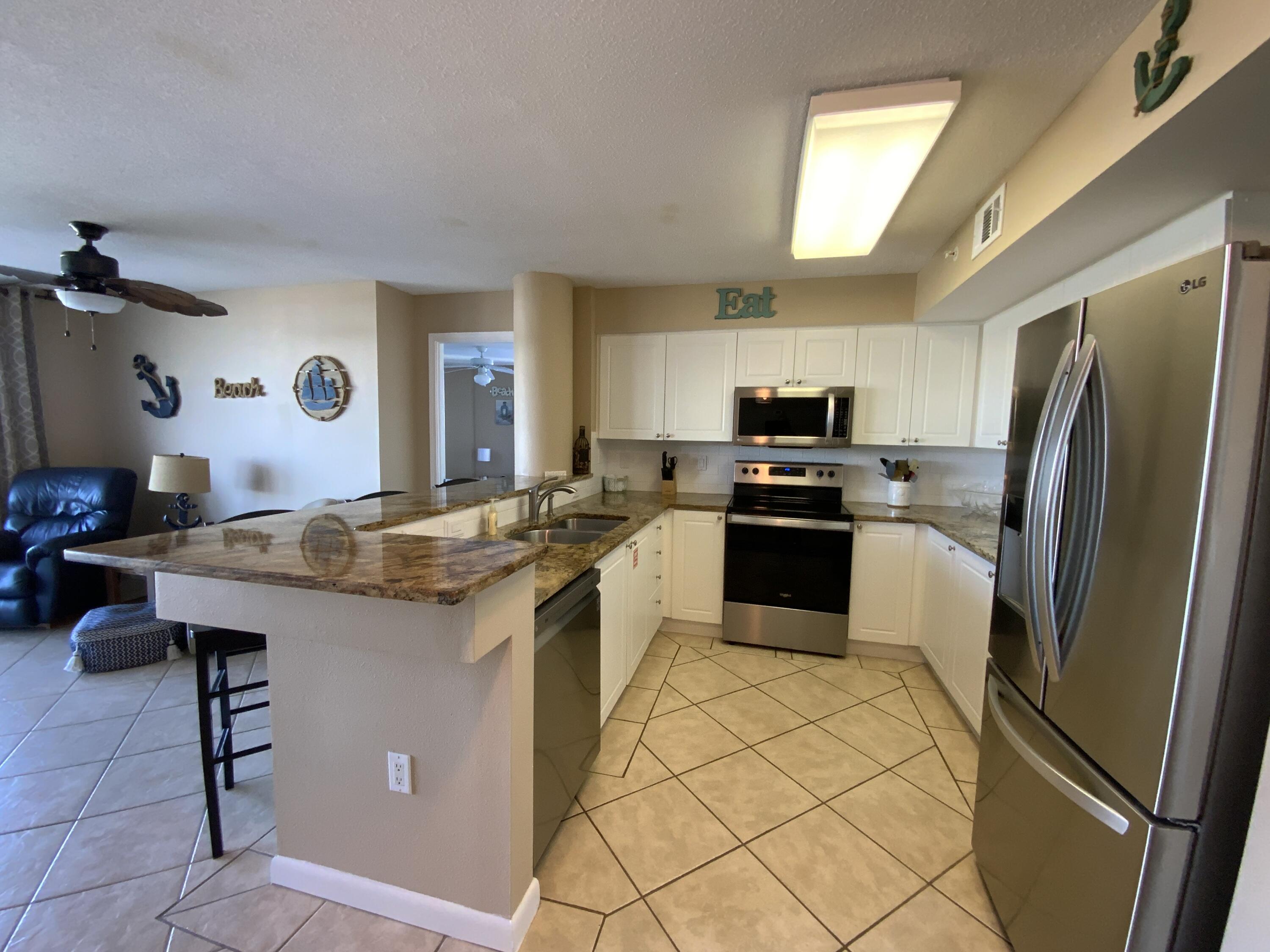 670 Santa Rosa Boulevard, Unit 503 Fort Walton Beach, FL 32548 - Photo 6 of 44 a kitchen with granite countertop a refrigerator stove and sink