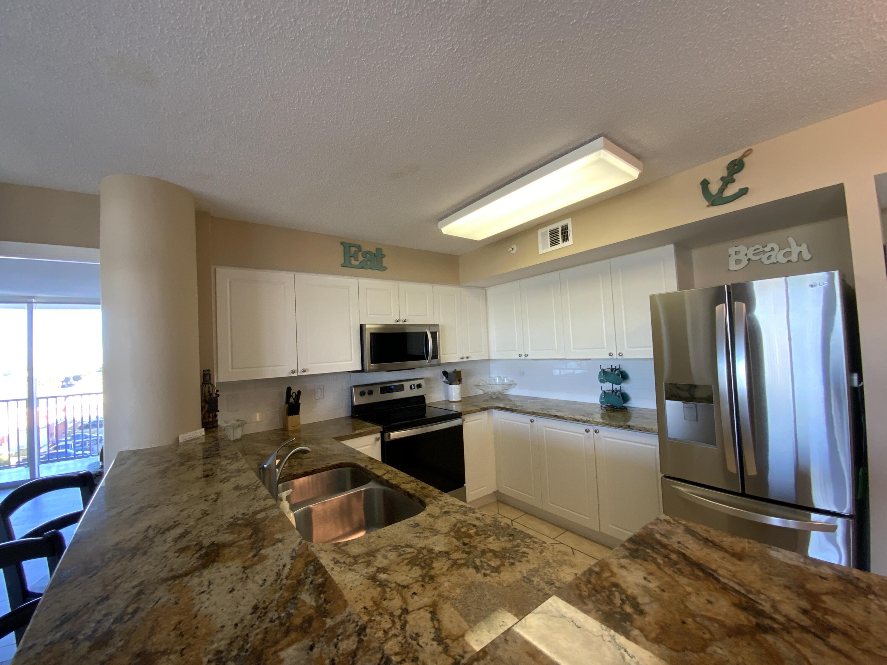 670 Santa Rosa Boulevard, Unit 503 Fort Walton Beach, FL 32548 - Photo 7 of 44 a kitchen with granite countertop a refrigerator and a stove top oven