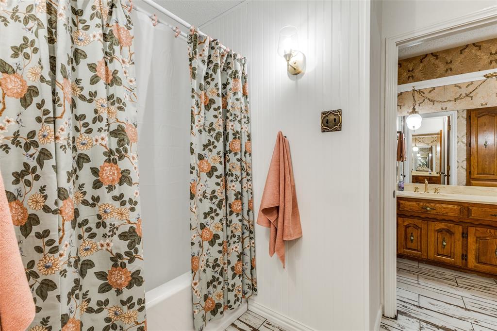 10615 Old Seagoville Road Dallas, TX 75217 - Photo 24 of 33 a bathroom with a shower curtain and a sink