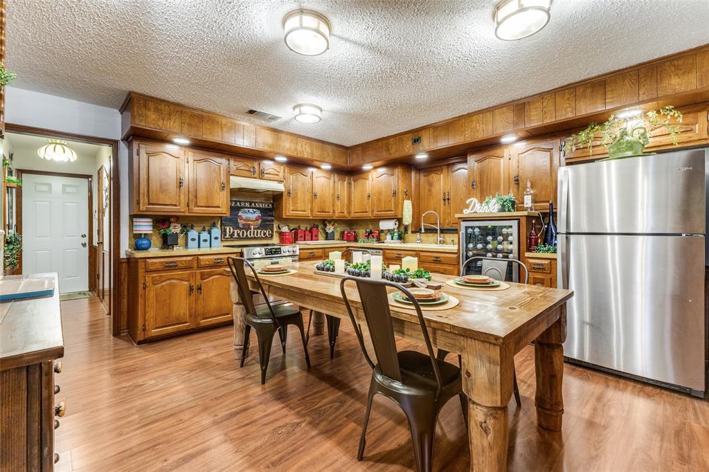 10615 Old Seagoville Road Dallas, TX 75217 - Photo 9 of 33 a kitchen with stainless steel appliances a dining table chairs refrigerator and sink