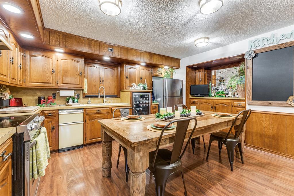 10615 Old Seagoville Road Dallas, TX 75217 - Photo 10 of 33 a kitchen with a table chairs stove and cabinets