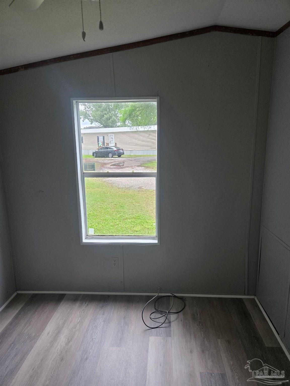 5675 Saufley Field Road, Unit 9 Pensacola, FL 32526 - Photo 4 of 15 a view of an empty room with wooden floor and a window