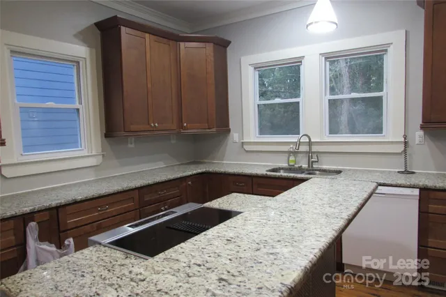 a kitchen with granite countertop a sink and a stove