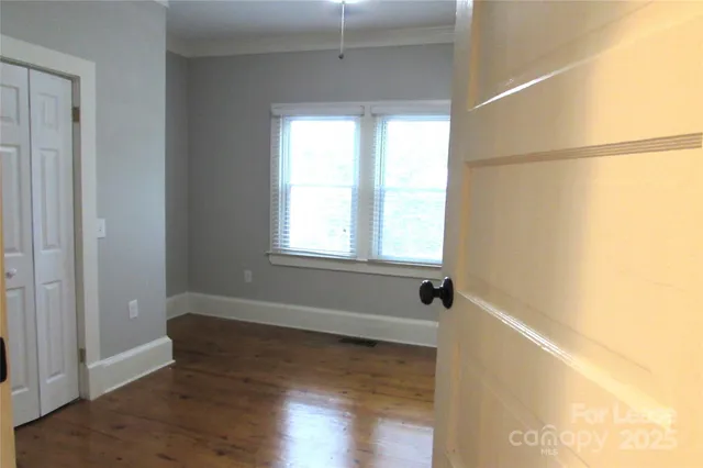 a view of a room with wooden floor and windows