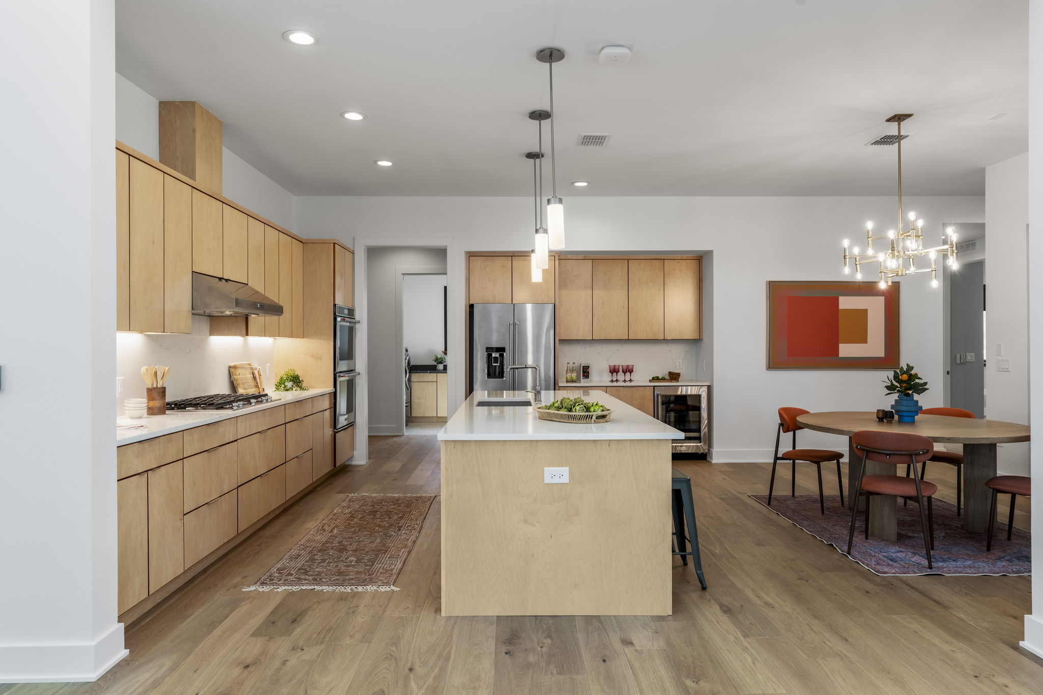 4602 Rue Street Austin, TX 78731 - Photo 10 of 39 a large kitchen with kitchen island a stove a sink a dining table and chairs