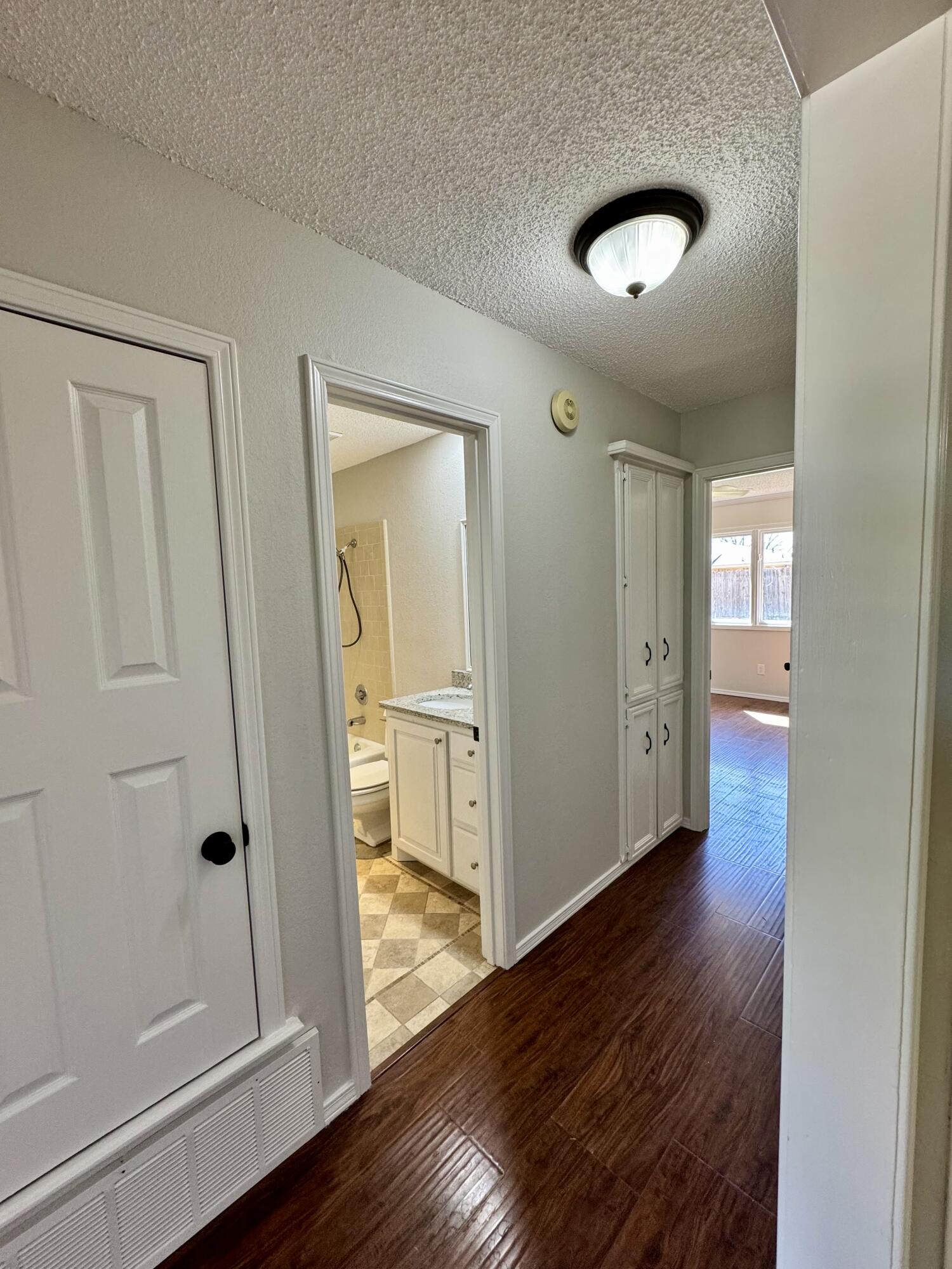 5421 94th Street Lubbock, TX 79424 - Photo 14 of 22 a view of a hallway with wooden floor