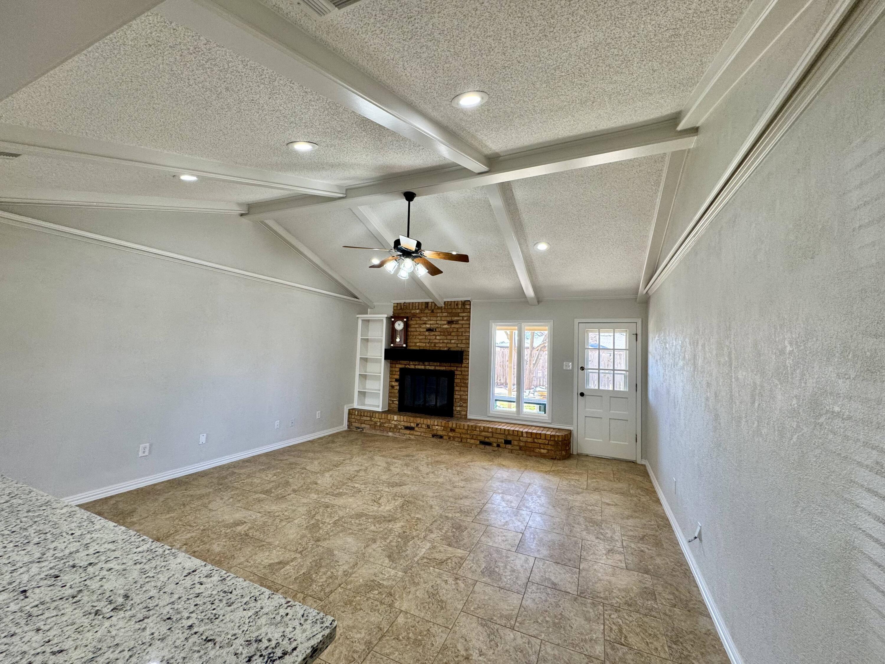 5421 94th Street Lubbock, TX 79424 - Photo 3 of 22 a view of an empty room with a fireplace and a window