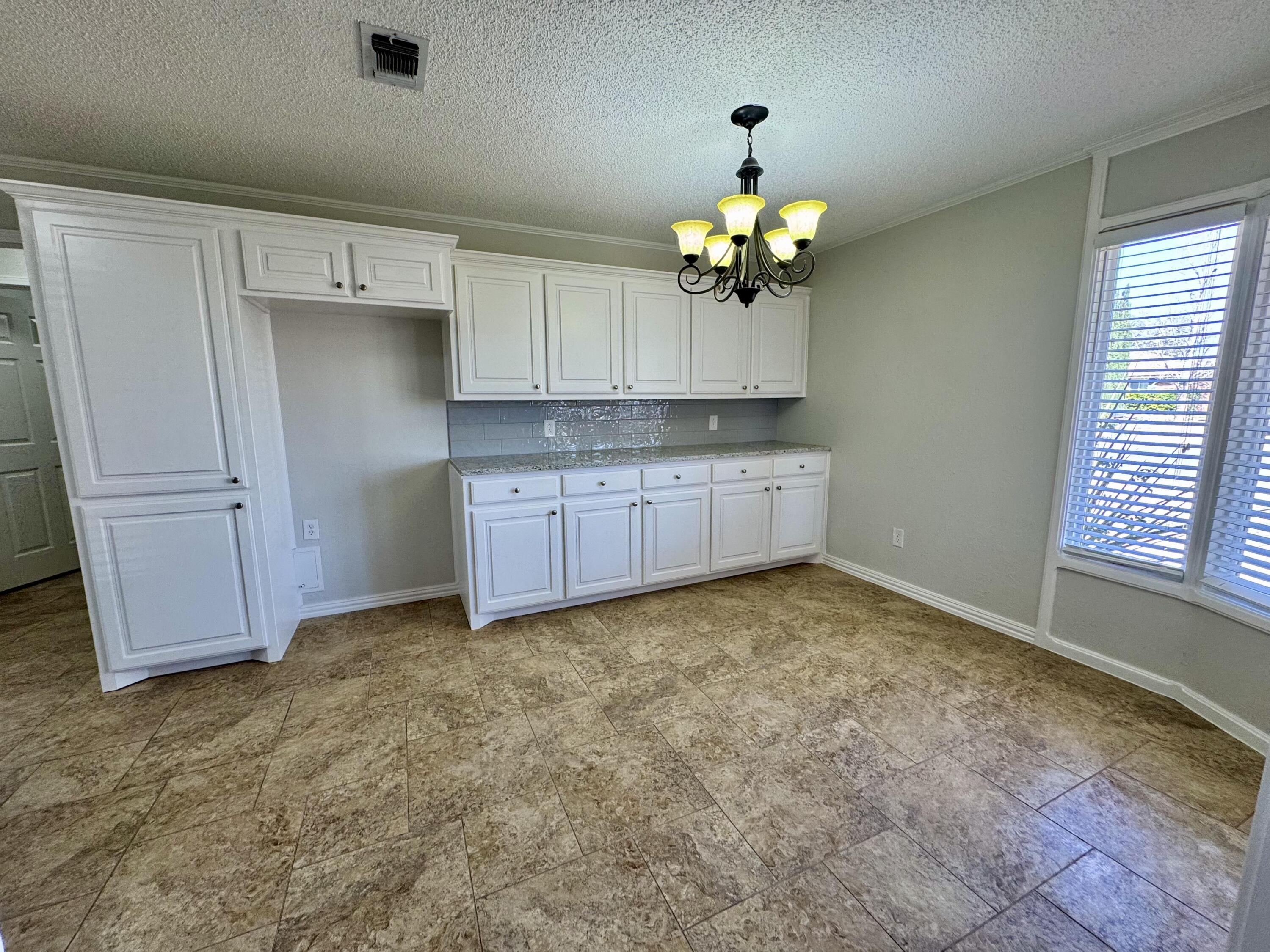 5421 94th Street Lubbock, TX 79424 - Photo 6 of 22 a view of kitchen with granite countertop cabinets and window