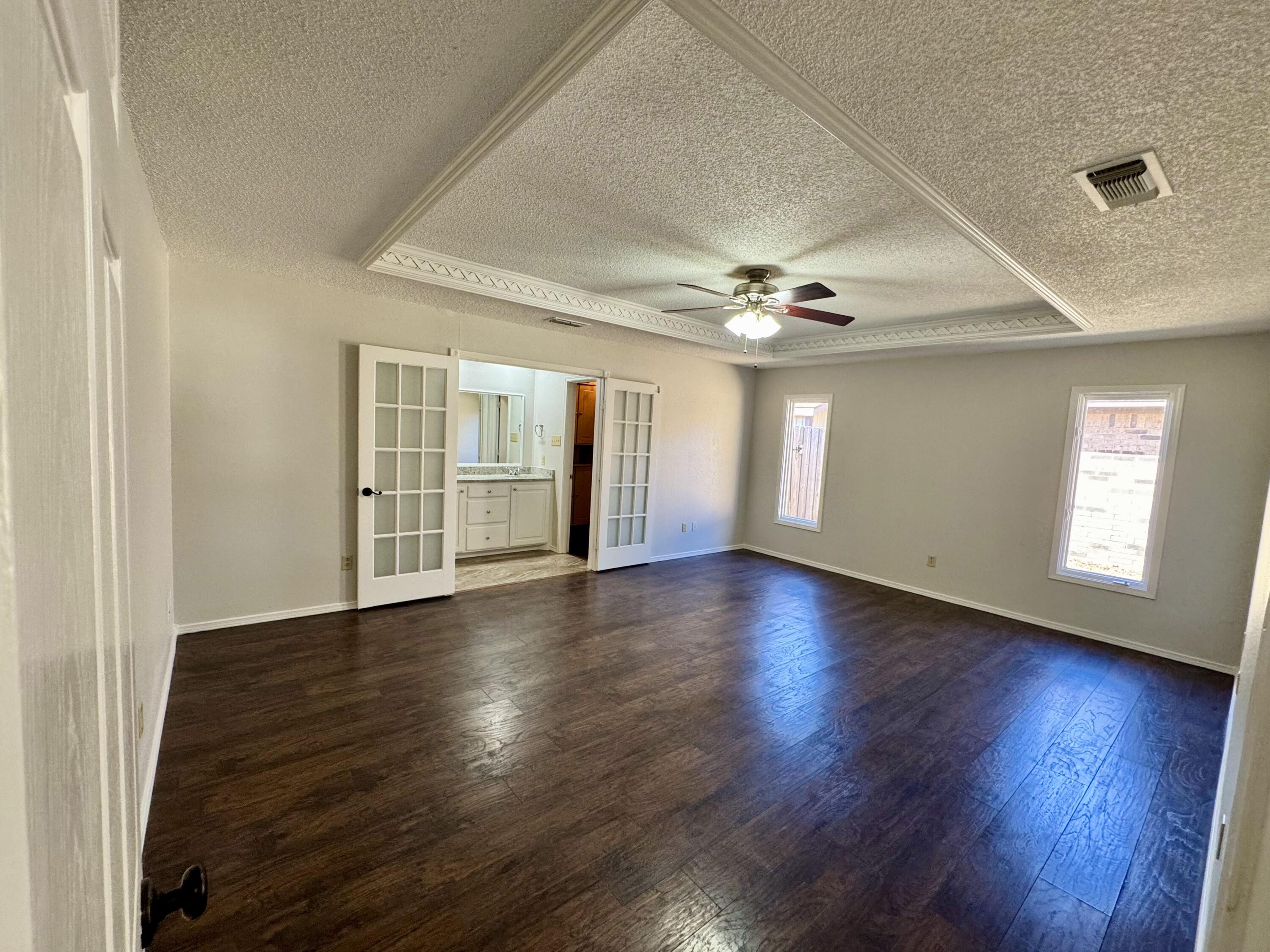 5421 94th Street Lubbock, TX 79424 - Photo 8 of 22 a view of an empty room with wooden floor and a window