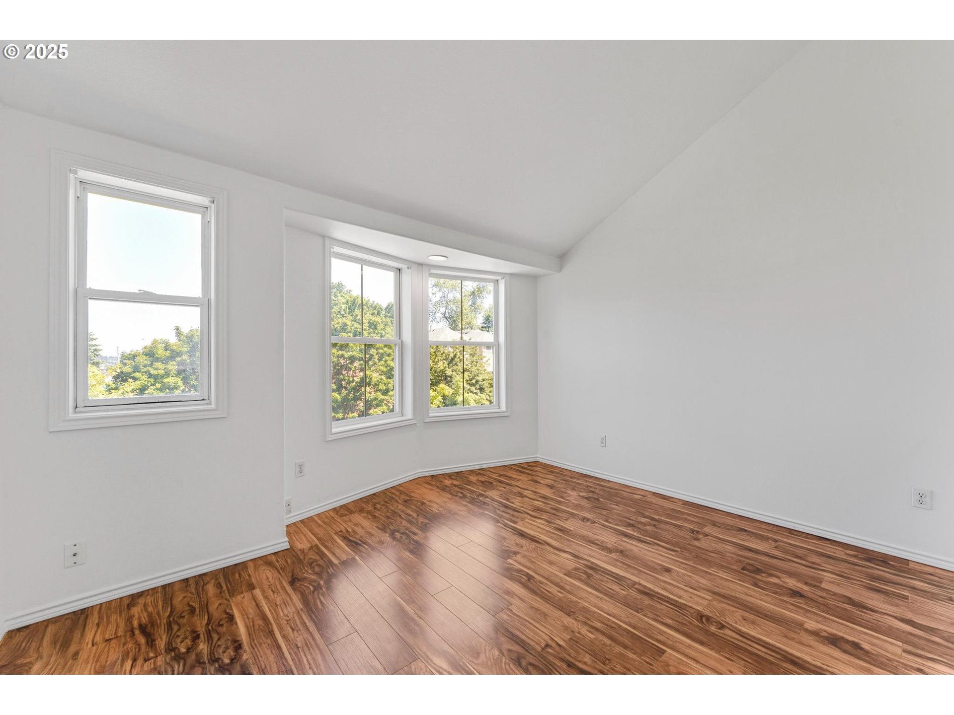 4815 Southwest 1st Avenue Portland, OR 97239 - Photo 19 of 43 a view of an empty room with wooden floor and a window