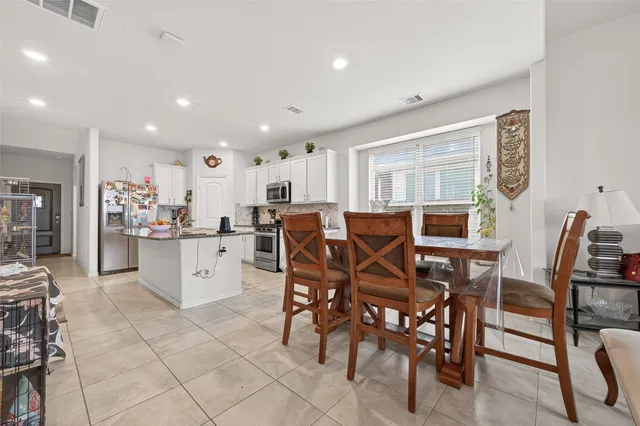 a kitchen with stainless steel appliances kitchen island granite countertop a table and chairs