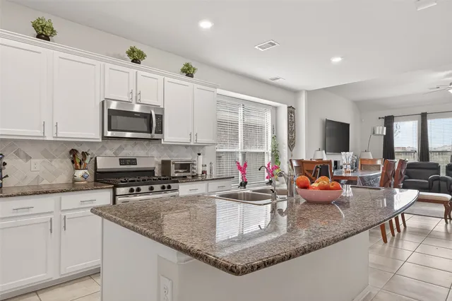 a kitchen with sink a stove and cabinets