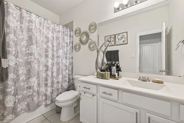 a bathroom with a granite countertop sink mirror vanity and toilet