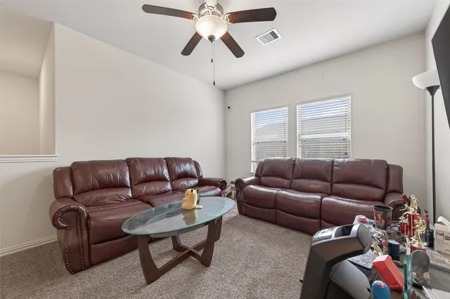 a living room with furniture a ceiling fan and a rug