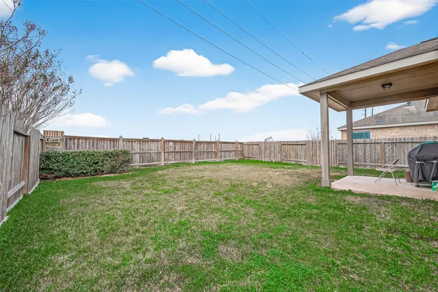 a view of a backyard with table and chairs and wooden fence