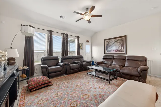 a living room with furniture ceiling fan and a window