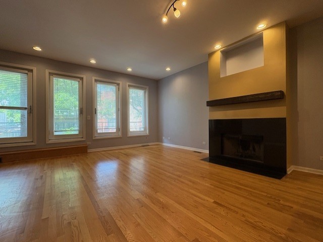 1543 North Hudson Avenue, Unit 2 Chicago, IL 60610 - Photo 2 of 19 an empty room with wooden floor fireplace and windows