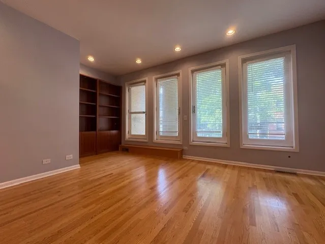 a view of room with wooden floor and windows