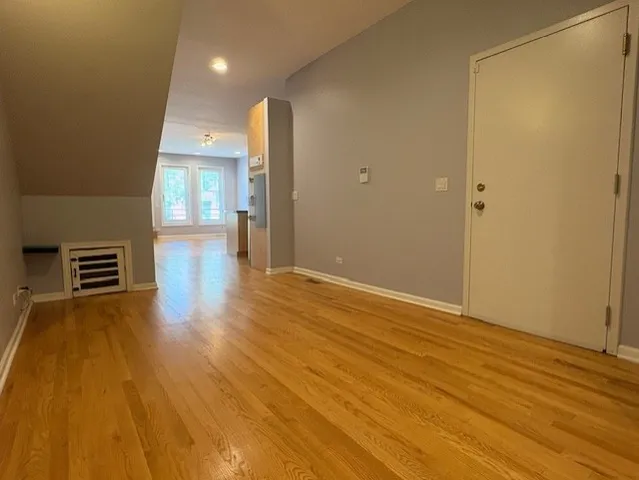 a view of empty room with wooden floor