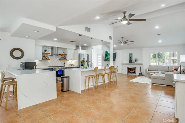 a kitchen with stainless steel appliances a stove a sink a dining table and chairs