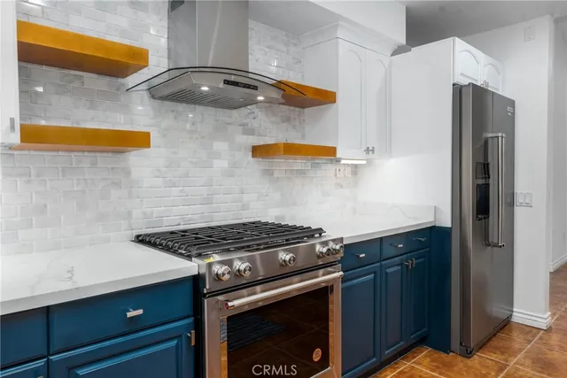 a kitchen with stainless steel appliances granite countertop a stove a sink and a refrigerator