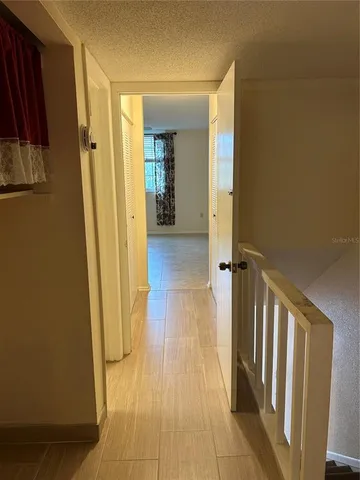 a view of a hallway with wooden floor and staircase