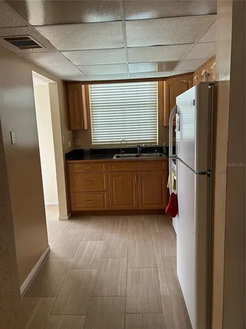 a kitchen with stainless steel appliances granite countertop a refrigerator a sink and a stove