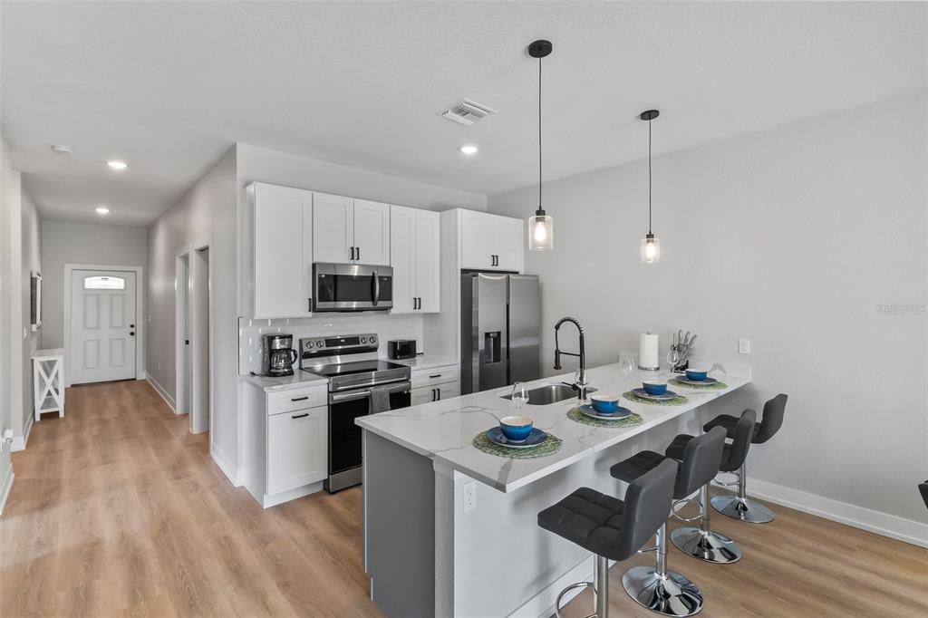 9155 Agate Street Port Charlotte, FL 33981 - Photo 23 of 30 a kitchen that has a table chairs stainless steel appliances and cabinets