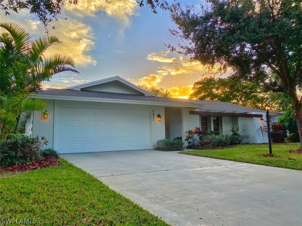 5692 Eichen Circle Fort Myers, FL 33919 - Photo 2 of 33 a front view of a house with a yard and garage