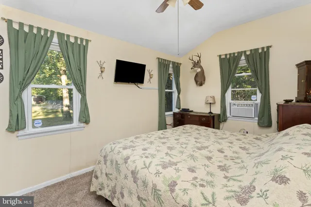 a bedroom with a bed mirror and a window