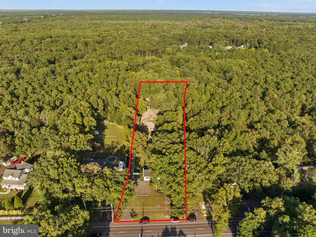 an aerial view of residential houses with outdoor space and trees