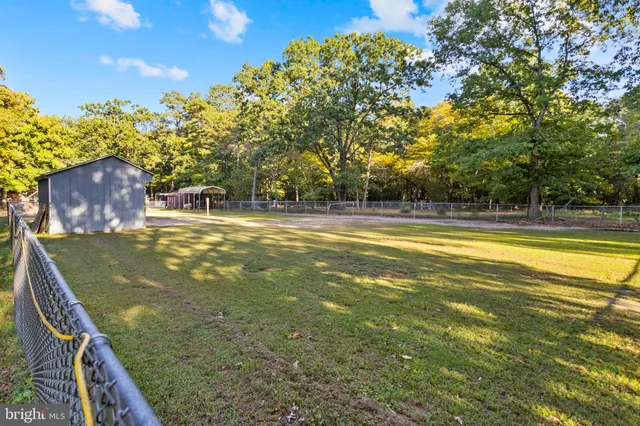 a view of a swimming pool with a patio and a yard