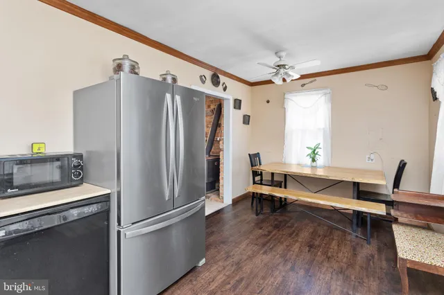 a kitchen with a refrigerator and table chair