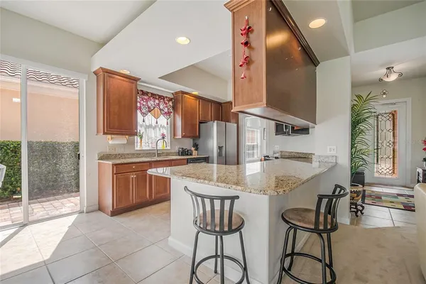 a kitchen with stainless steel appliances granite countertop a sink and a refrigerator