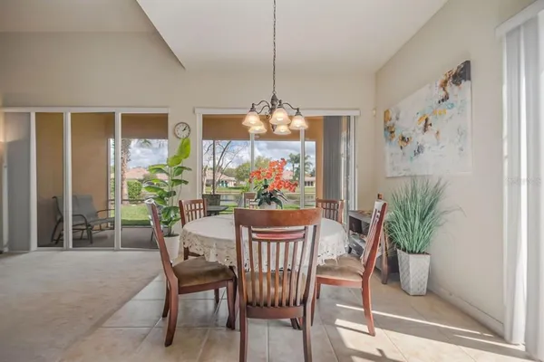 a dining room with furniture potted plants and a chandelier